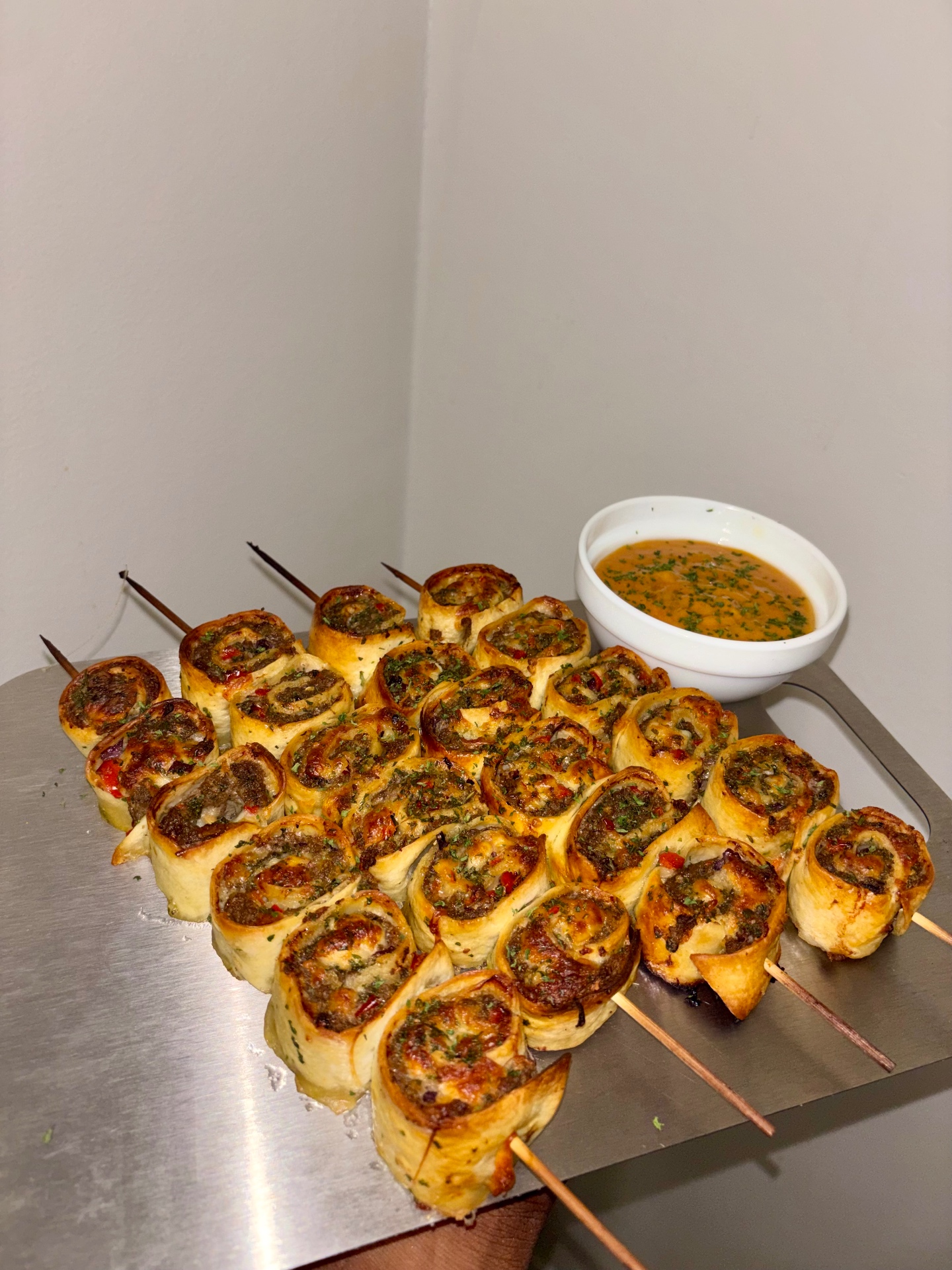 Pinwheel kebabs finished with dipping sauce